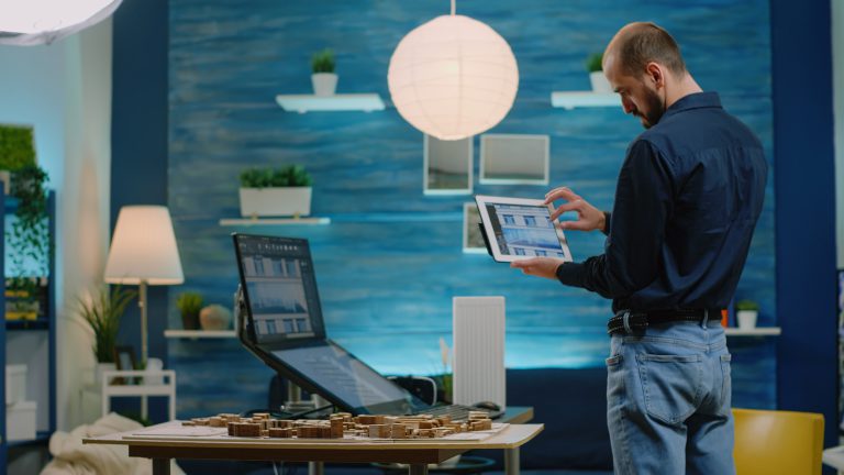 Architect looking at tablet with building model for development